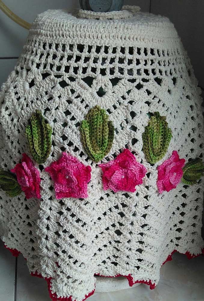 Crochet bottle cover made with string and finished with crochet flowers and leaves