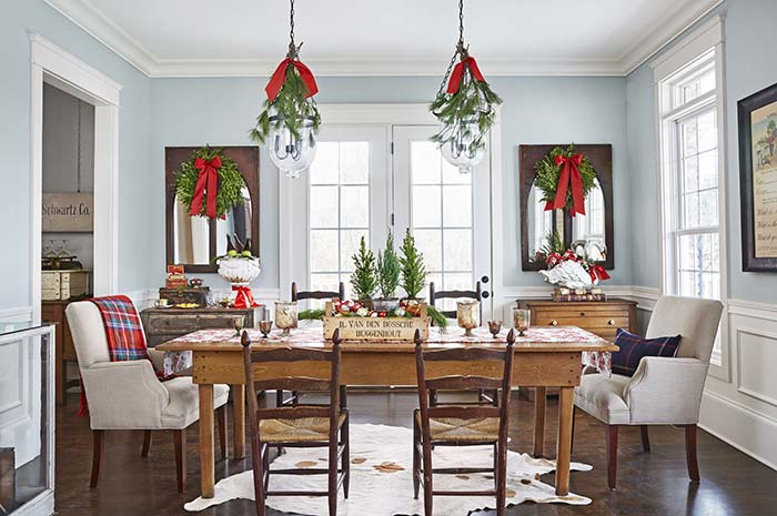 Here, the decoration of the room and the table is symmetrical and entirely based on traditional Christmas ornaments in green and red