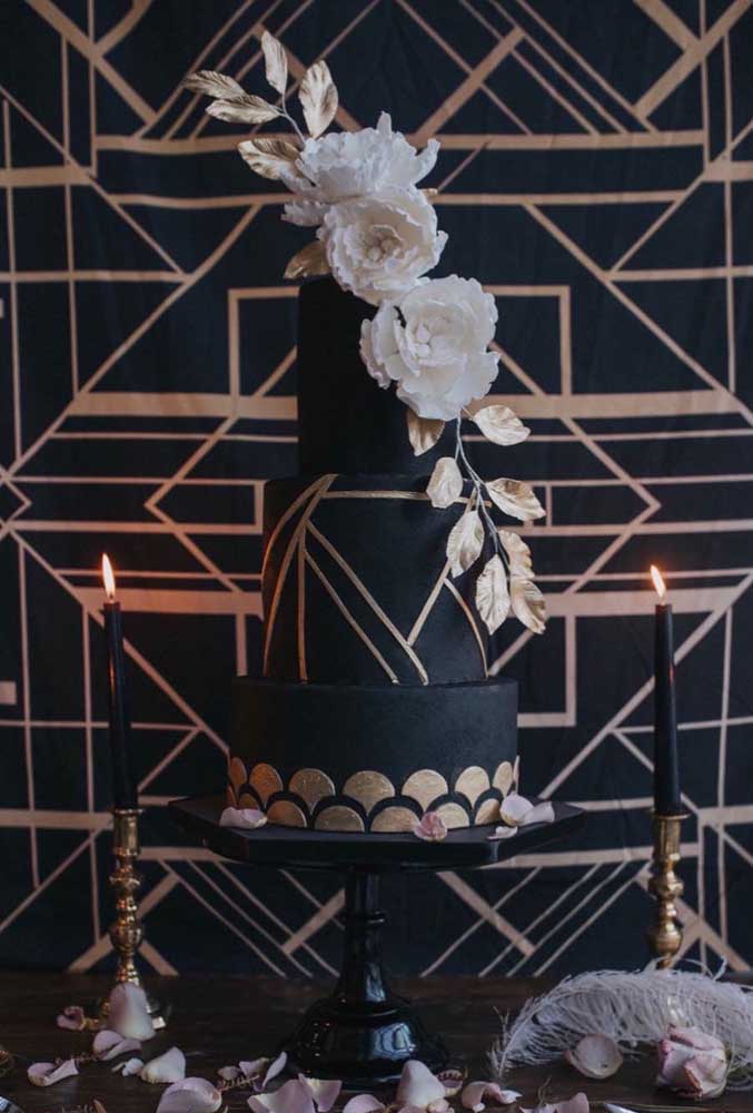 Masquerade cake decorated with black American paste and white flowers. The golden details finish off the candy