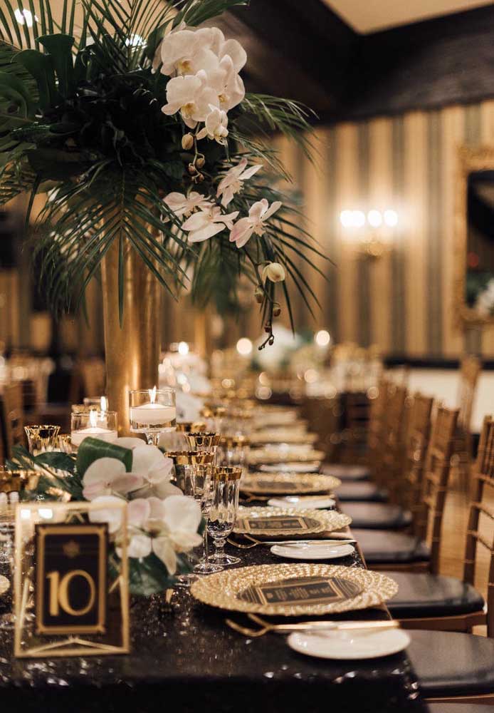 Tropical flowers and leaves decorate the centerpiece of this elegant masquerade ball