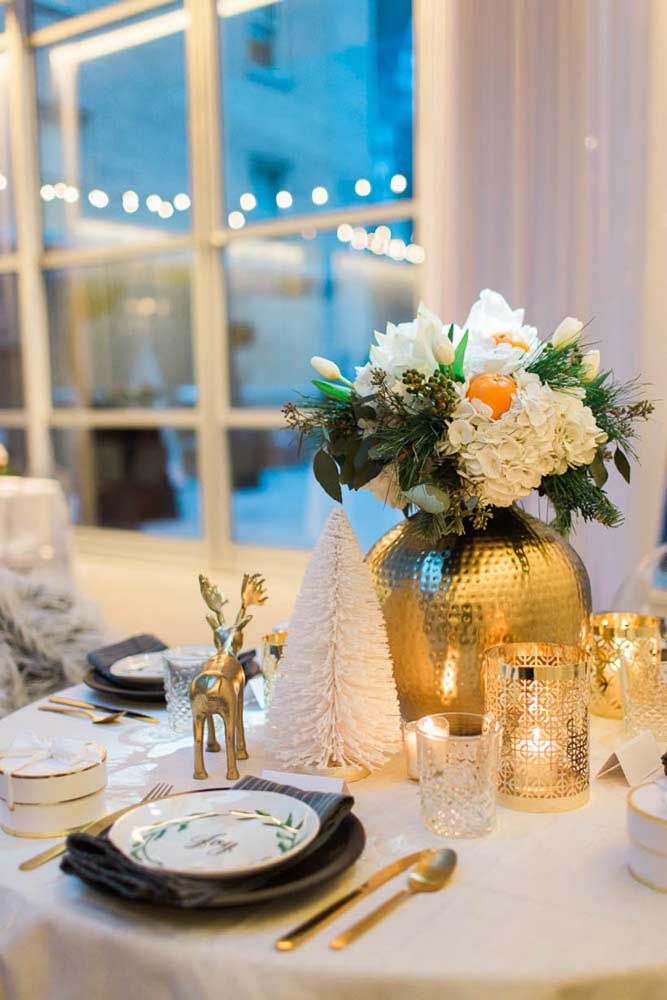 An elegant and charming golden vase with white flowers was the Christmas ornament chosen for this table