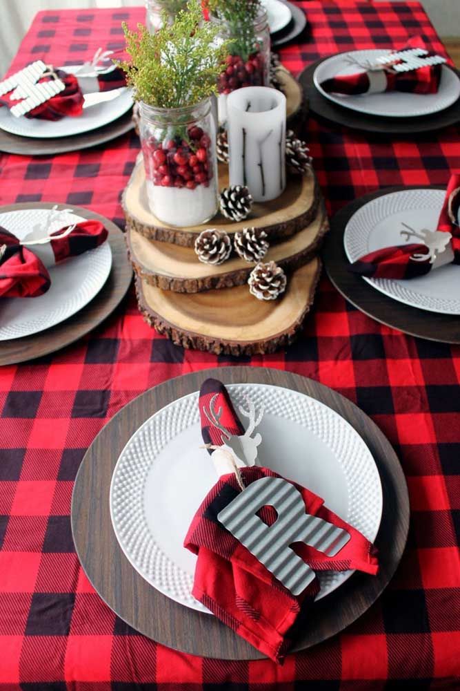 To complete the charm of the checkered tablecloth, a Christmas centerpiece made with wooden cuts, pine cones and candles