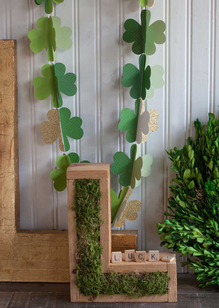 String of paper clovers accompanied by the letter L for Lucky, or luck in Portuguese