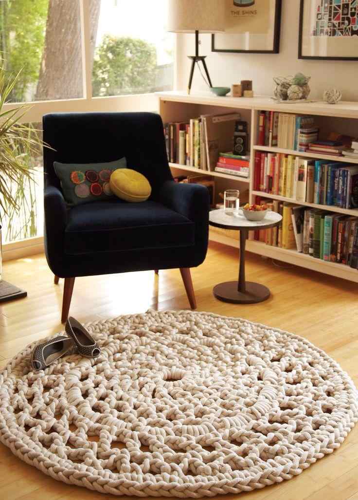 Round and beige crochet rug for living room with armchair