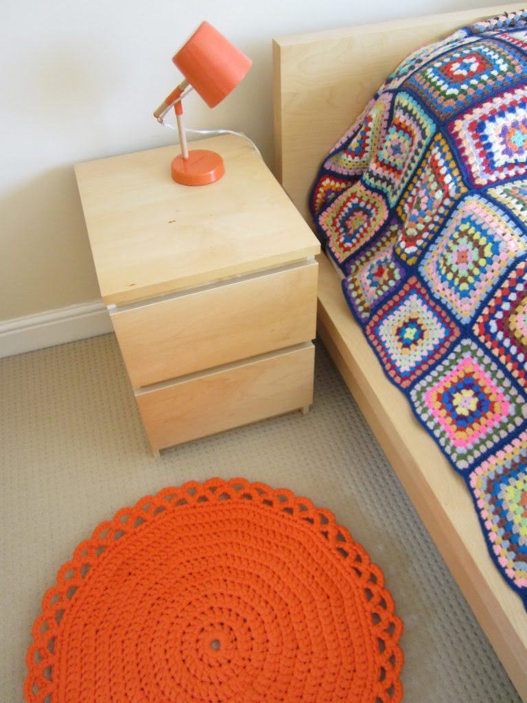 Round crochet rug beside the bed