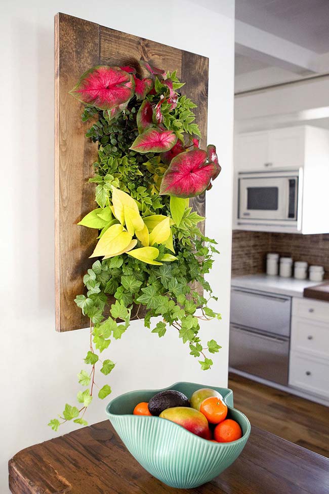 A living, natural picture of anthuriums and ivy decorates the space between the dining room and the kitchen