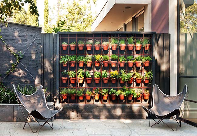 Wire mesh serves as a support for clay pots with herbs and spices