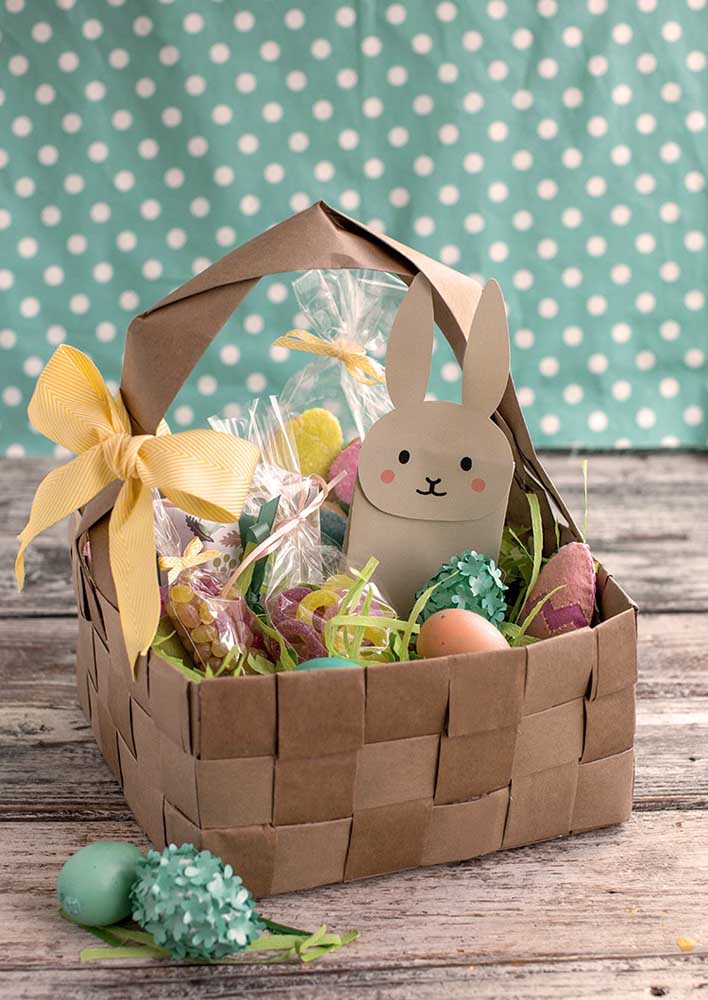 Easter basket made with strips of braided paper and filled with chocolate eggs