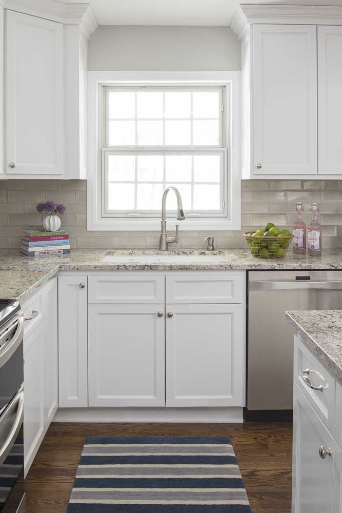 Classic white kitchen design with arabesque gray granite; on the floor a beautiful wooden floor