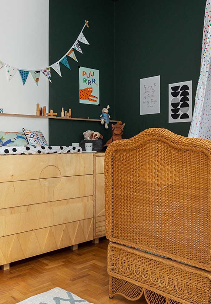 The black wall and the wicker crib are the great differential of this male baby room