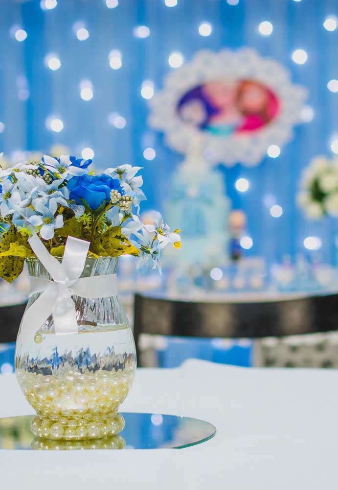 Frozen party centerpiece made with blue flowers matching theme colors