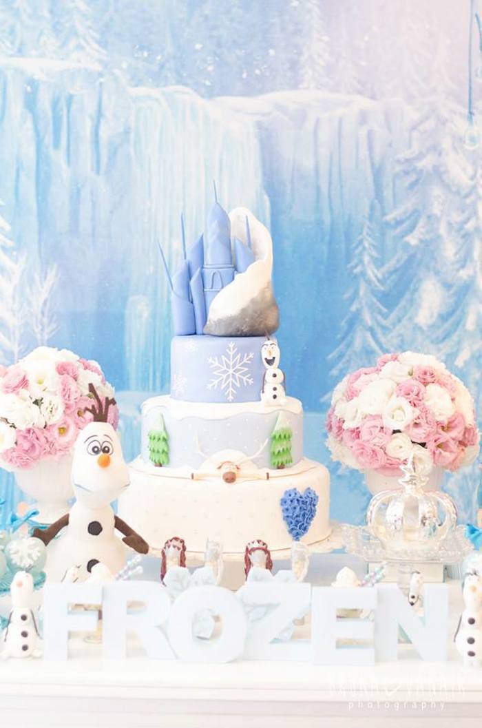 Well-crafted, three-story cake with Queen Elsa's castle on top.