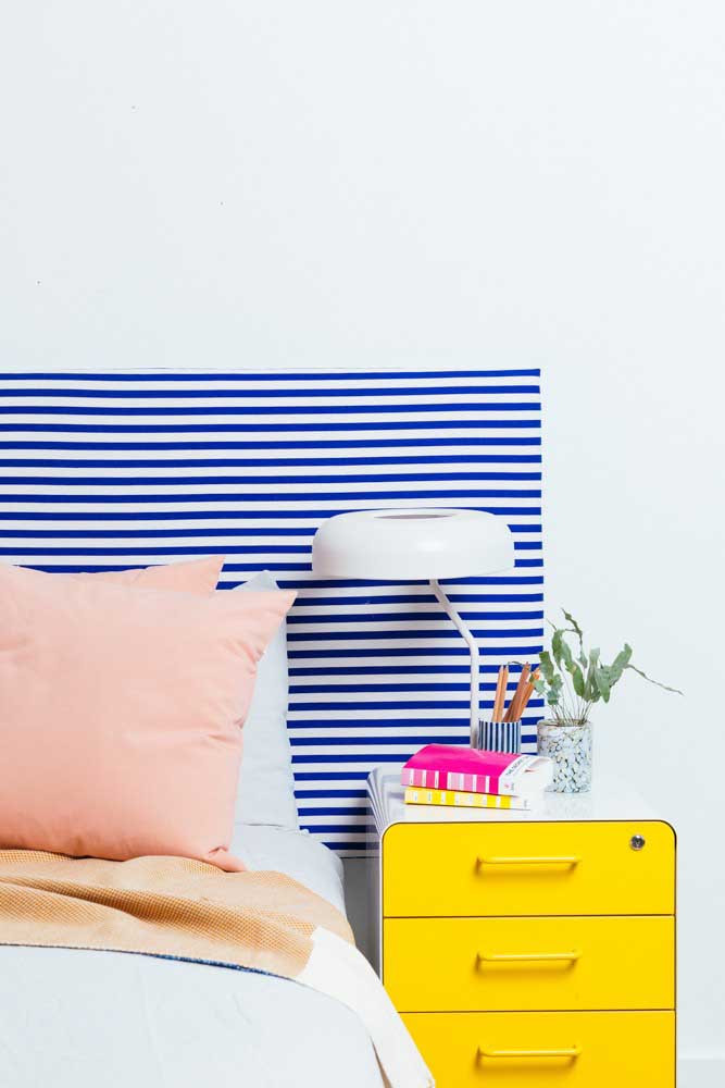 Here, the white background was highlighted by the striped headboard and the yellow nightstand.