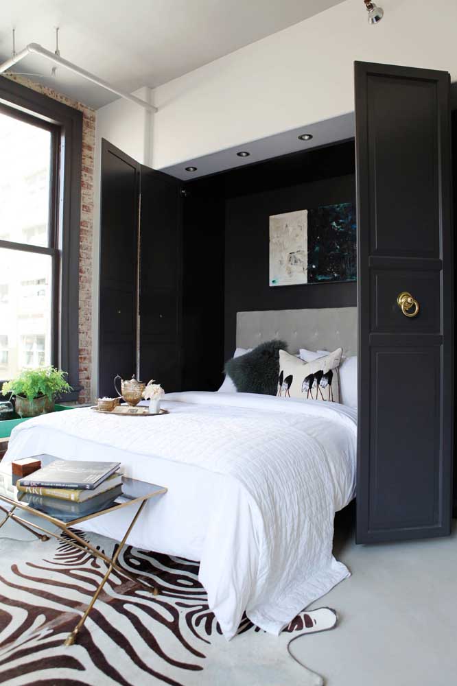 Feminine single room with bold and modern solutions, including faux leather rug and black doors