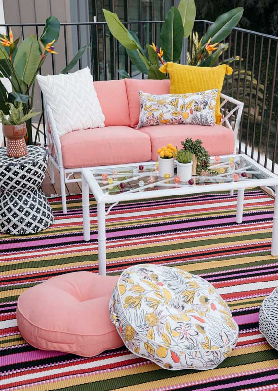 Modern wooden balcony sofa surrounded by plants