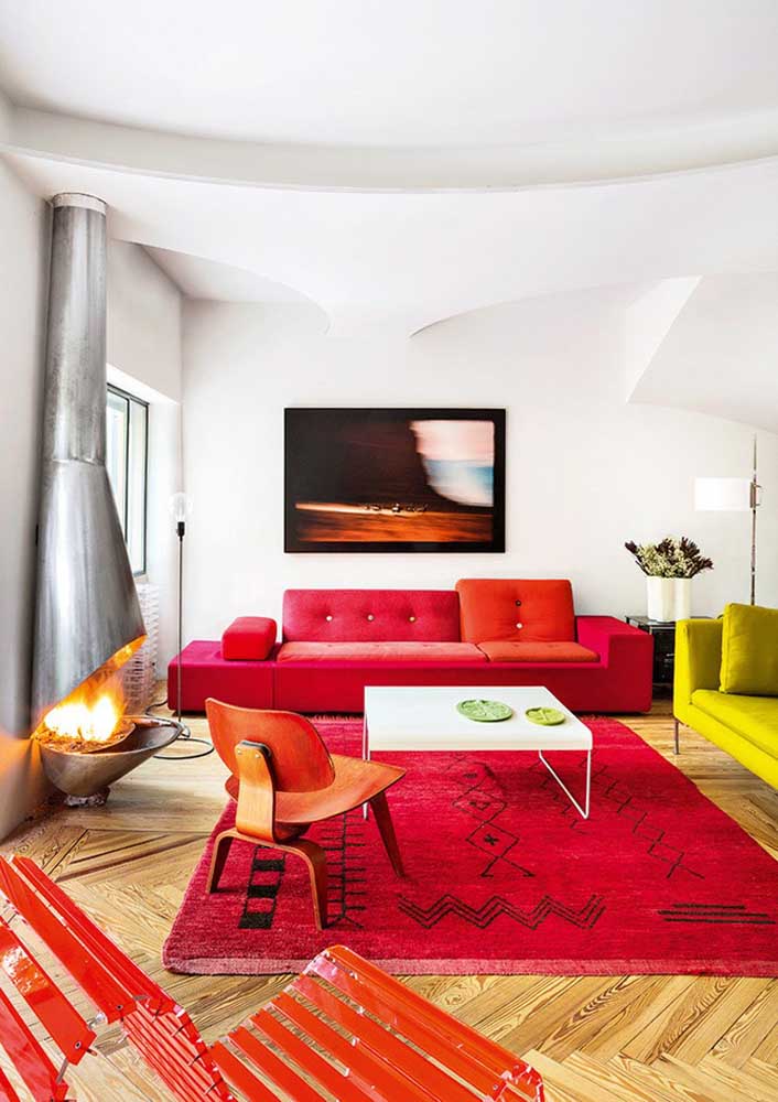 Red sofa, carpet and armchairs stand out in this white-walled room. The lemon yellow sofa makes the counterpoint in the decoration