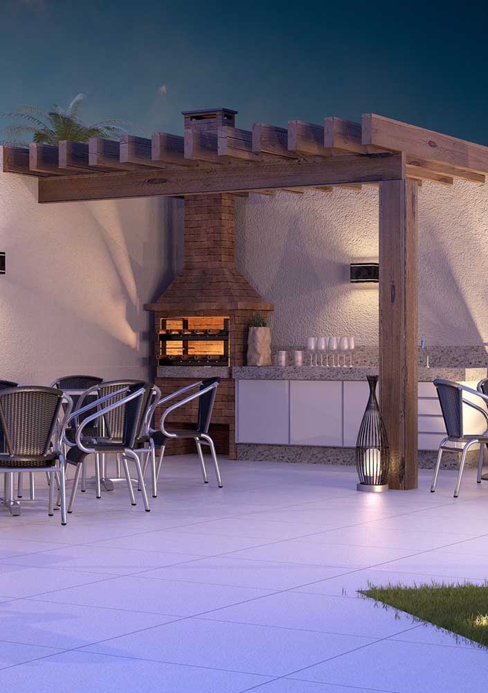 The external area of ​​this house gained a space for the brick barbecue with granite sink and pergola cover