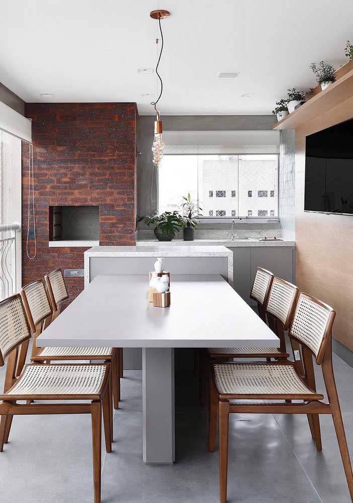 Gourmet space with exposed brick barbecue equipped with an island and a large table to welcome visitors