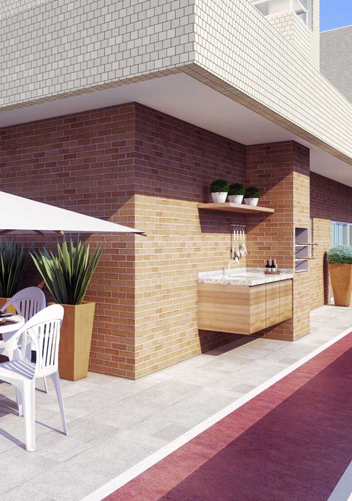 In this open gourmet space, the barbecue area appropriates the ceramic brick covering used on the wall