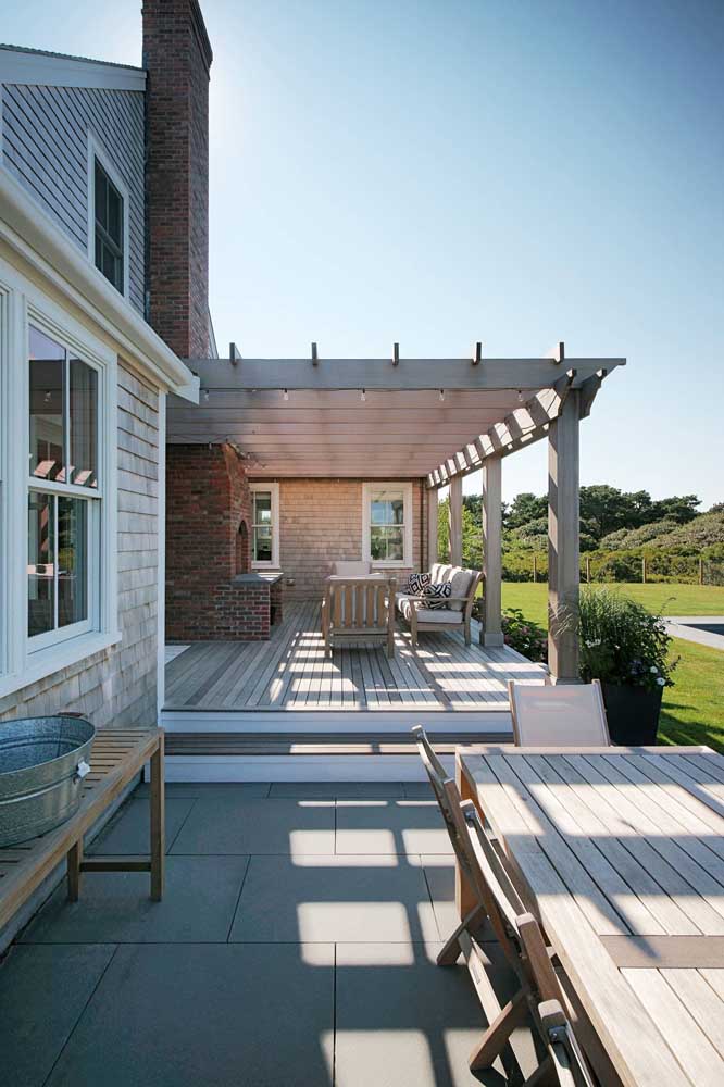 Brick barbecue facing the open area of ​​the house with pergola cover