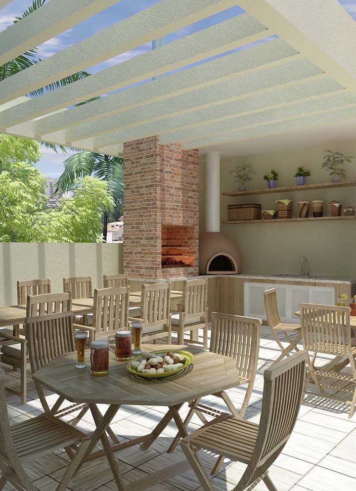 This social area with elegant and clean gourmet space has a brick barbecue and wood oven