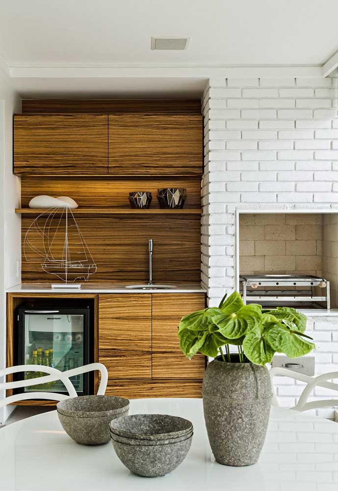 The balcony of this apartment gained a beautiful gourmet space with a brick barbecue painted in white