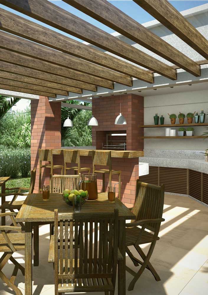 Wood and exposed brick always go well together. Here, the materials can be found on the barbecue, on the furniture and on the pergola