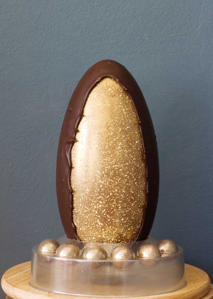 Easter egg decorated with golden tones in a beautiful presentation; highlight to the small eggs that accompany it