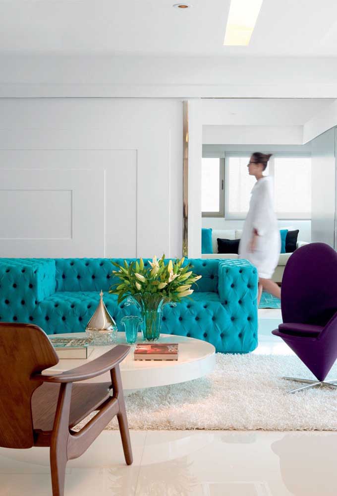 Turquoise blue sofa with tufted finish for the contemporary living room with white walls and wooden pieces; the great highlight of the environment