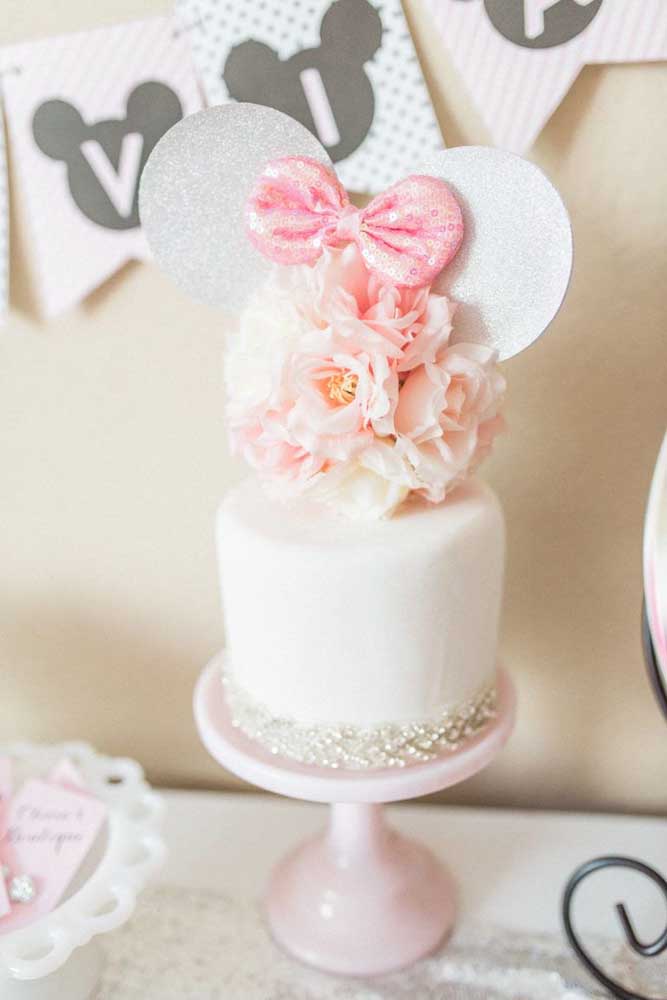 A super delicate and romantic Minnie cake in shades of white and pink decorated with mini pearls and flowers