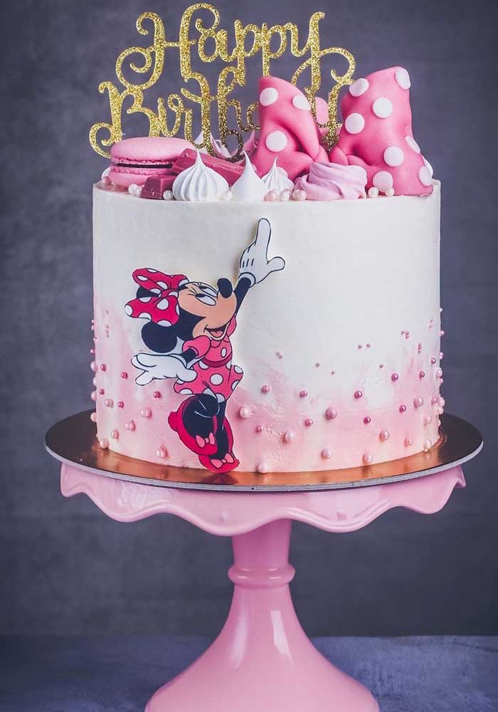 Minnie cake with simple whipped cream topping. The highlight is the different types of sweets on the cake