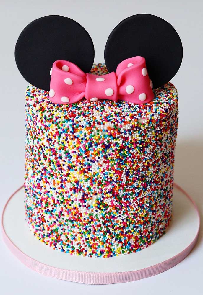 Minnie cake decorated with colorful sprinkles. To characterize the theme, little ears and bow on top