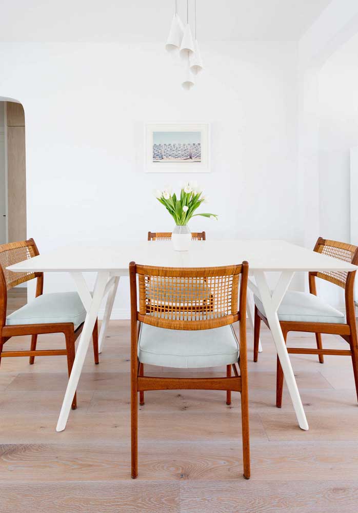 Cadeiras de fibra contrastadas pela mesa de jantar branca