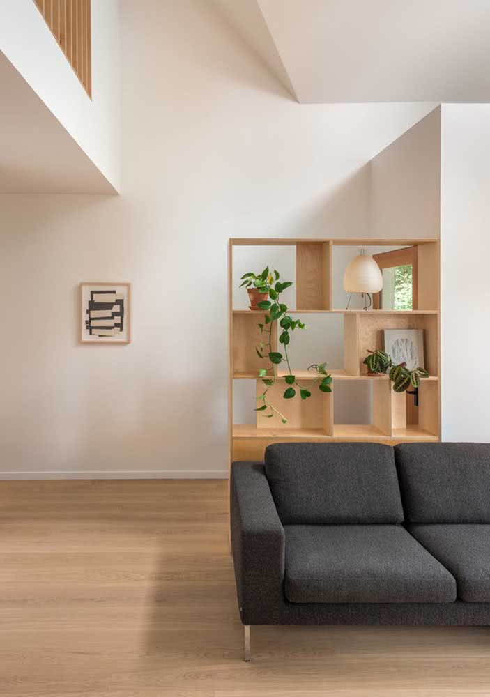 Estante de madeira clara para complementar o visual da sala minimalista