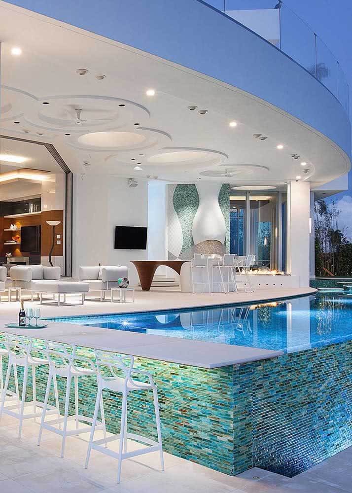 Uma área de lazer luxuosa com bar integrado à piscina 