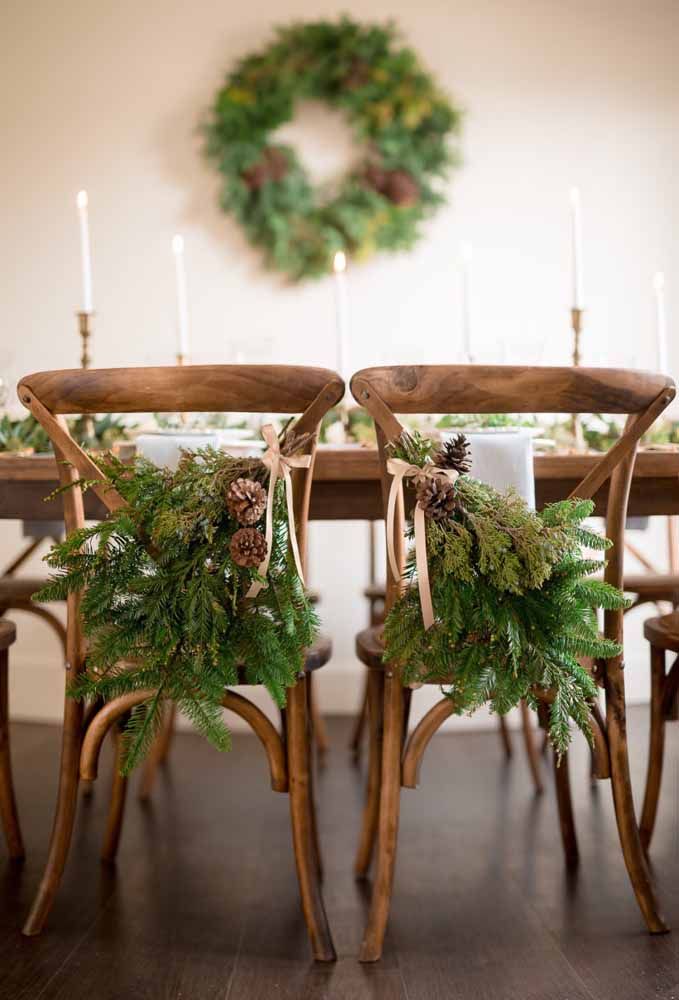 Um arranjo com flores preso nas cadeiras dá um toque diferenciado na decoração da mesa de natal