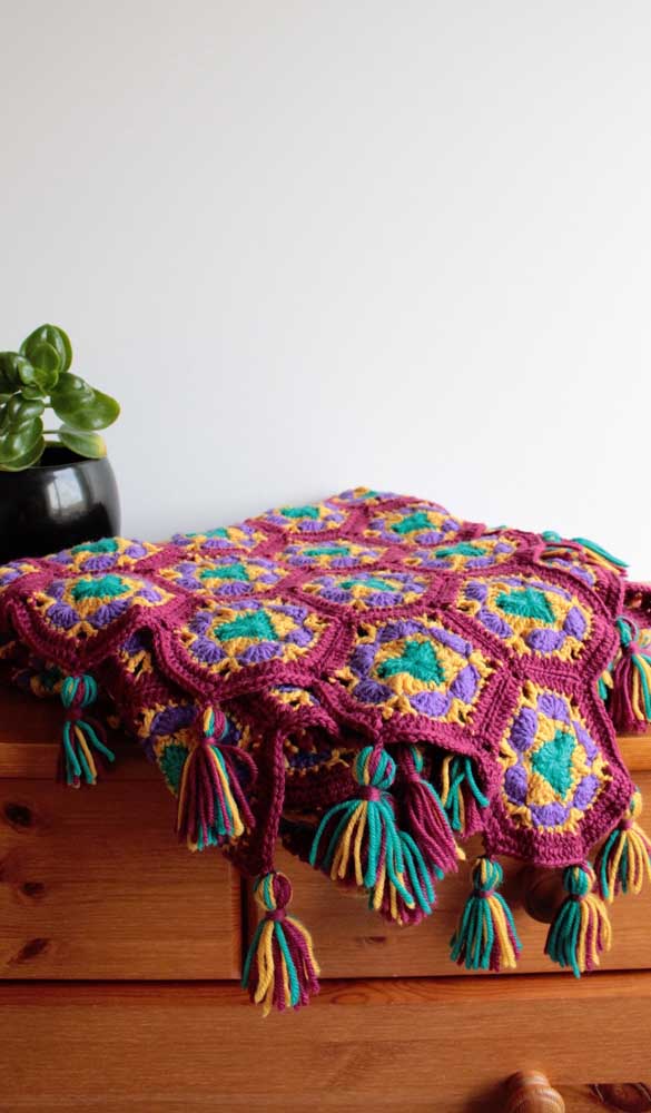 Cores quentes e contrastantes são o destaque dessa outra manta de crochê. O modelo perfeito para uma decor boho