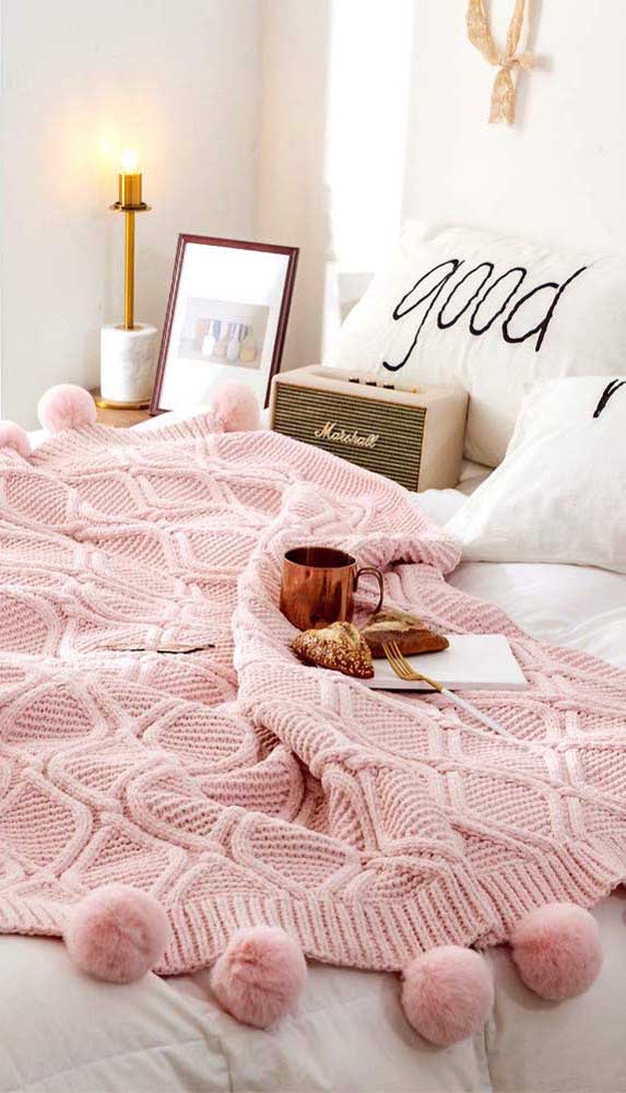 A manta de crochê rosa pode ser delicada ou moderna, dependendo do restante da decoração. Aqui, por exemplo, ela complementa um ambiente moderno em preto e branco