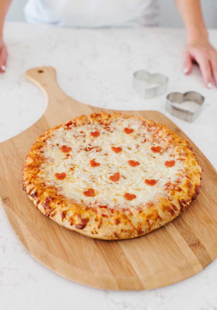 Coraçõezinhos delicados decoram essa pizza de muçarela 