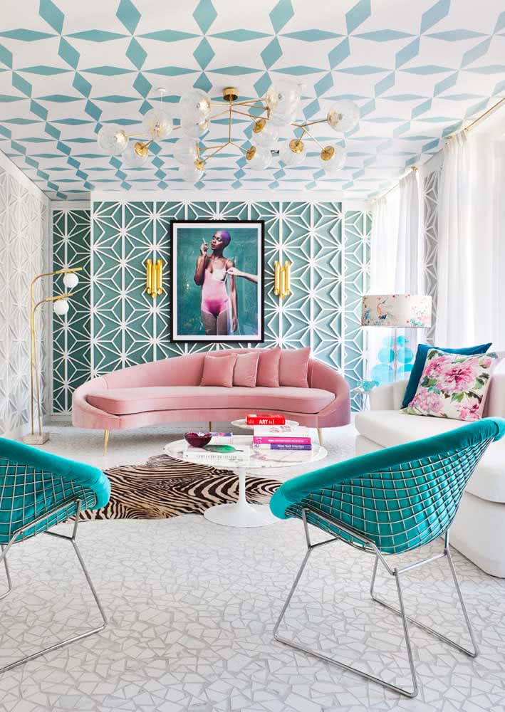 Sofá rosa com design contemporâneo valorizado pela decoração em tons de azul, branco e dourado