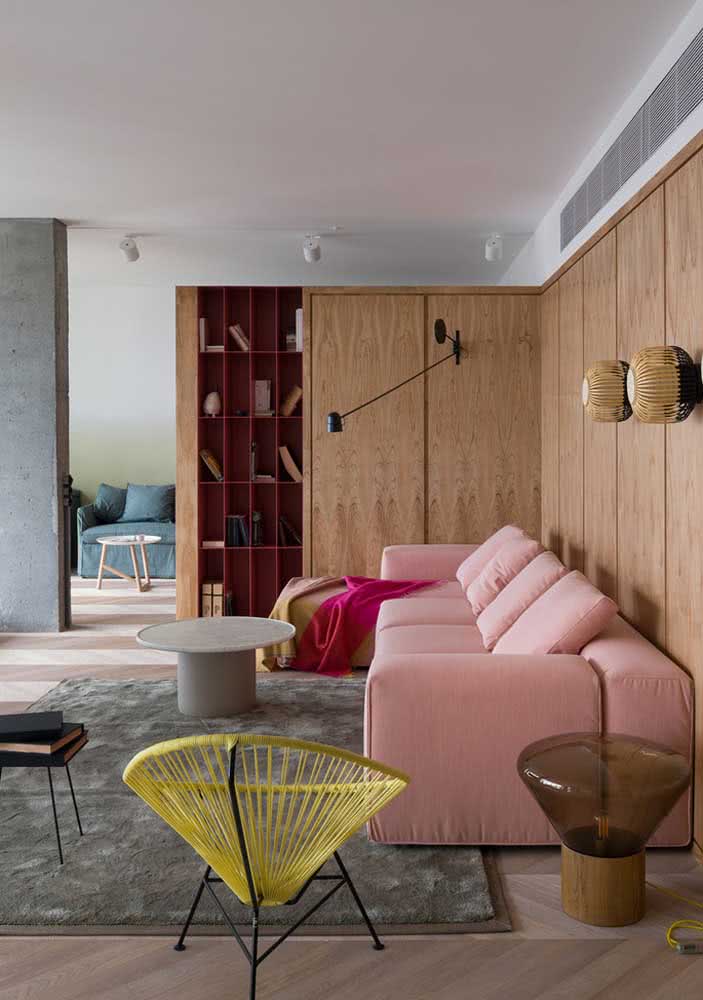Que tal combinar um sofá rosa de design moderno com painel de madeira e cadeira Acapulco amarela?