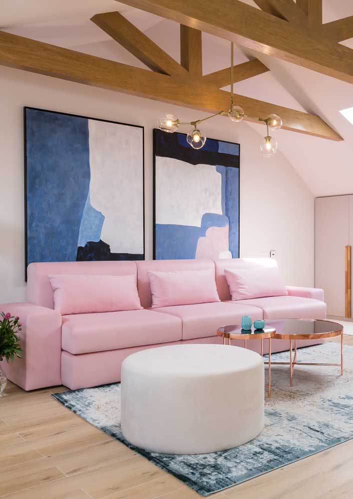 Sofá rosa claro na sala de tons de azul, branco, dourado e detalhes em madeira