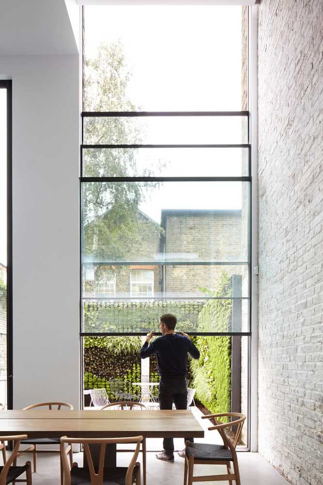 Gigante, essa janela guilhotina traz beleza e funcionalidade para a sala da casa moderna