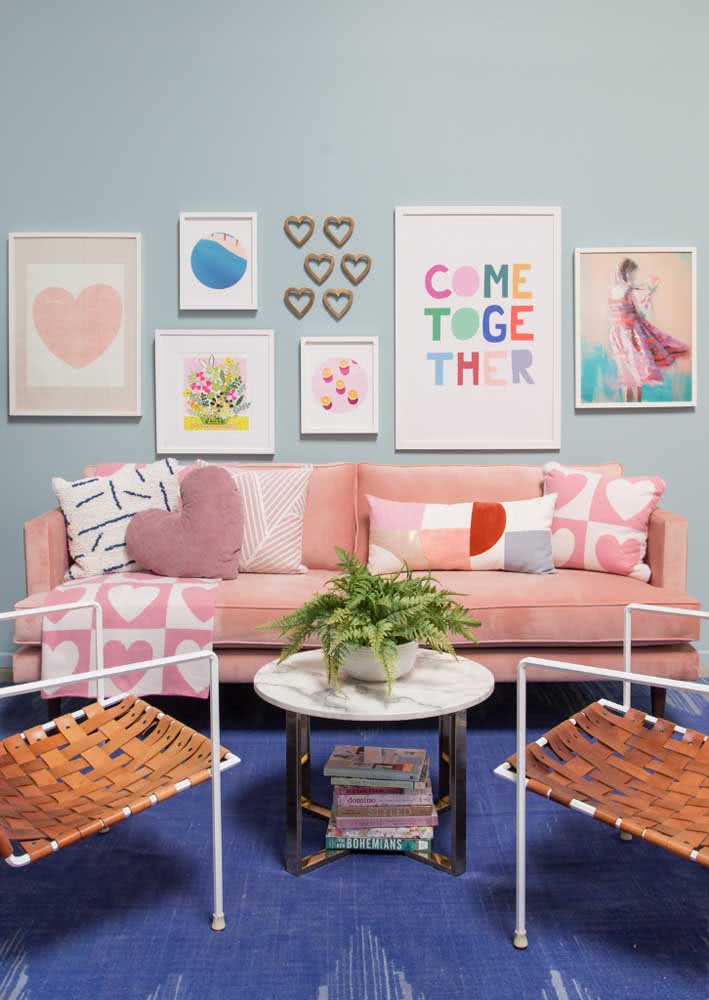 Contraste divertido e animado entre o sofá rosa e a parede e o tapete azul