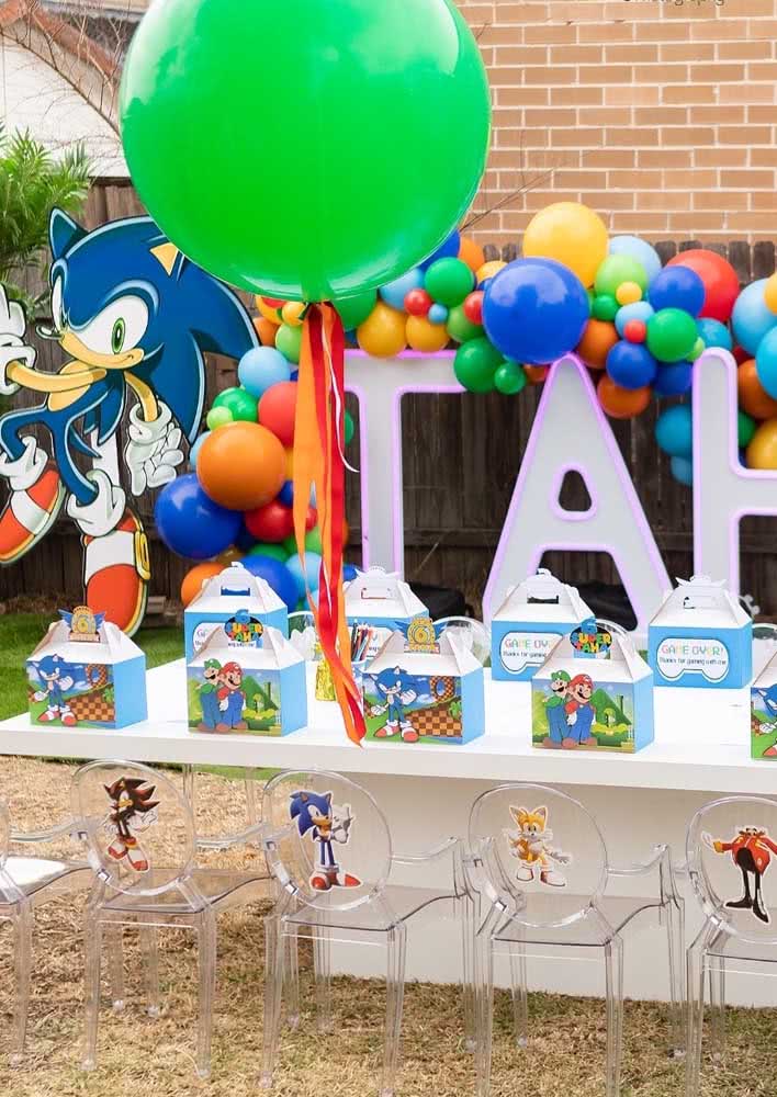 Festa Sonic ao ar livre. A mesa posta traz uma sacolinha para cada convidado e as cadeiras são marcadas pelos personagens