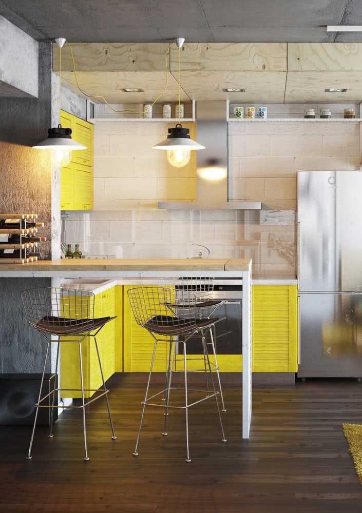 Moderna, essa cozinha amarela mescla madeira de pinus com concreto aparente