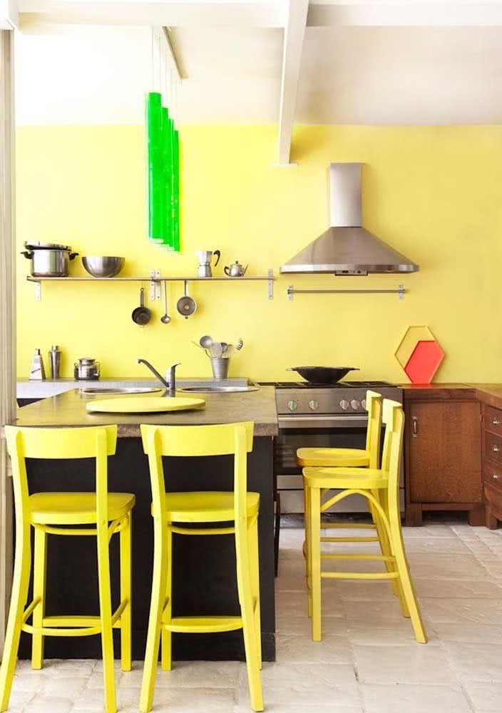 Amarelo claro na parede da cozinha combinando com as cadeiras